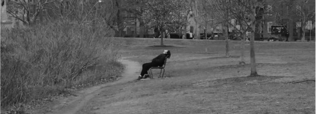 XSONG seated alone in an open field